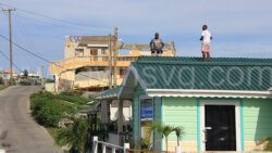 Workers repair a roof in Canouan on Saturday, Aug. 24, 2024. 